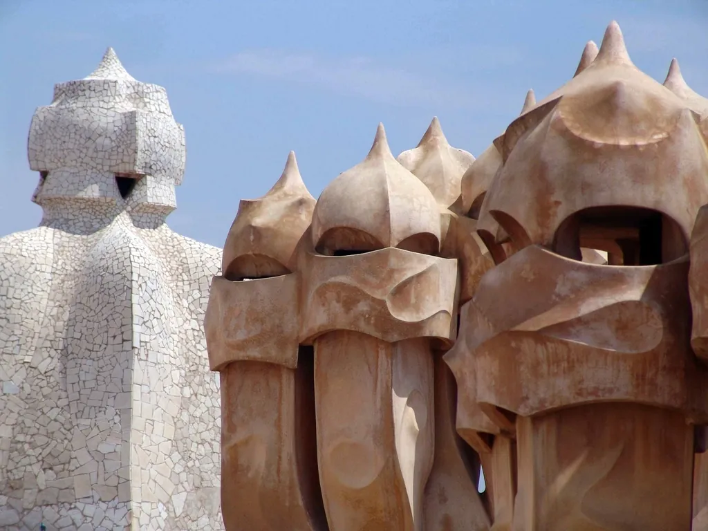 Chimeneas de formas orgánicas de un edificio modernista contra el cielo