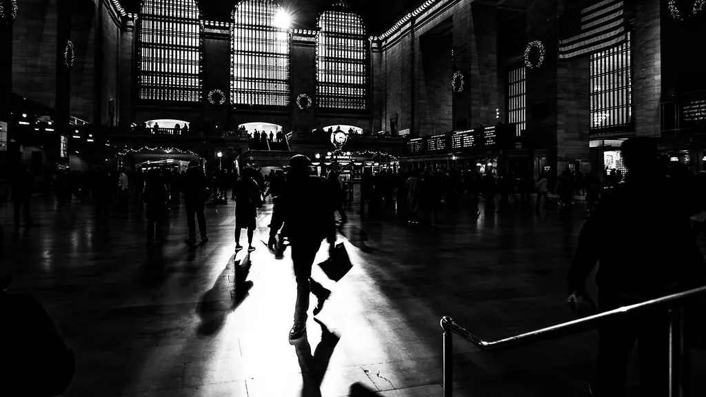 Siluetas atravesando la luz de una gran estación