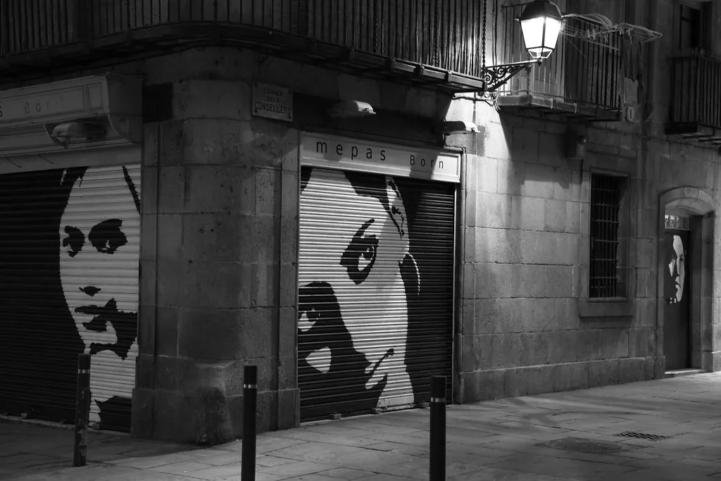 Retratos pintados en las persianas de una calle nocturna