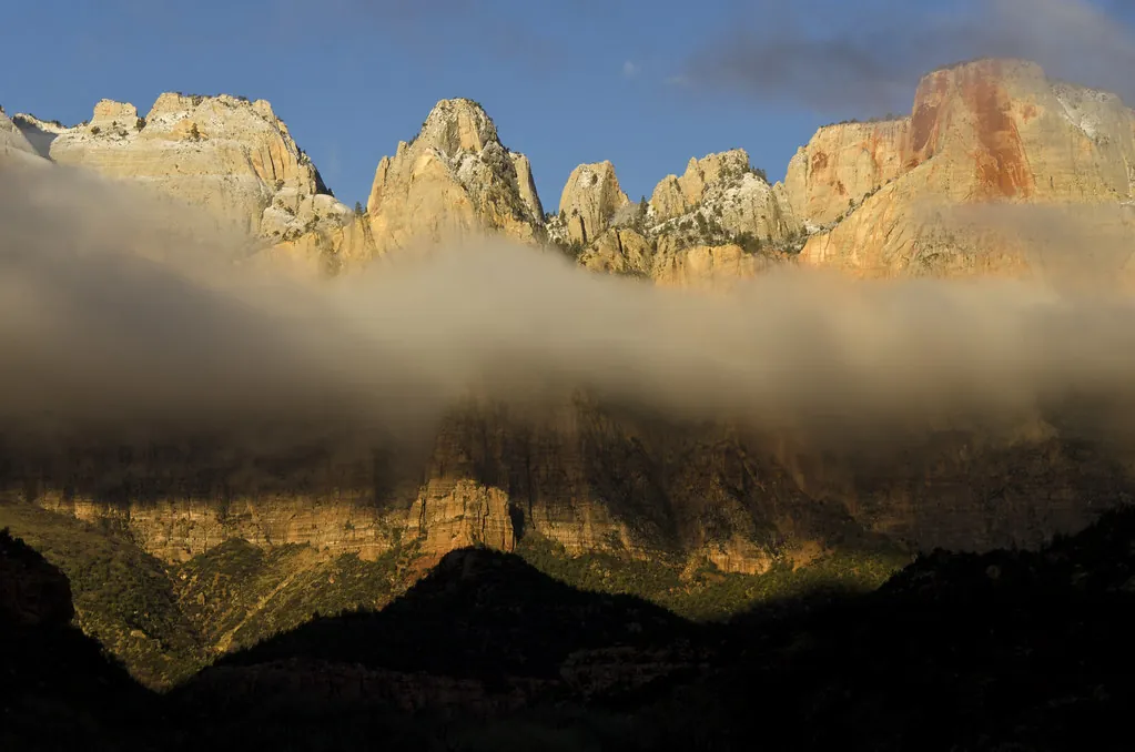 Crestas rocosas iluminadas sobre un mar de nubes