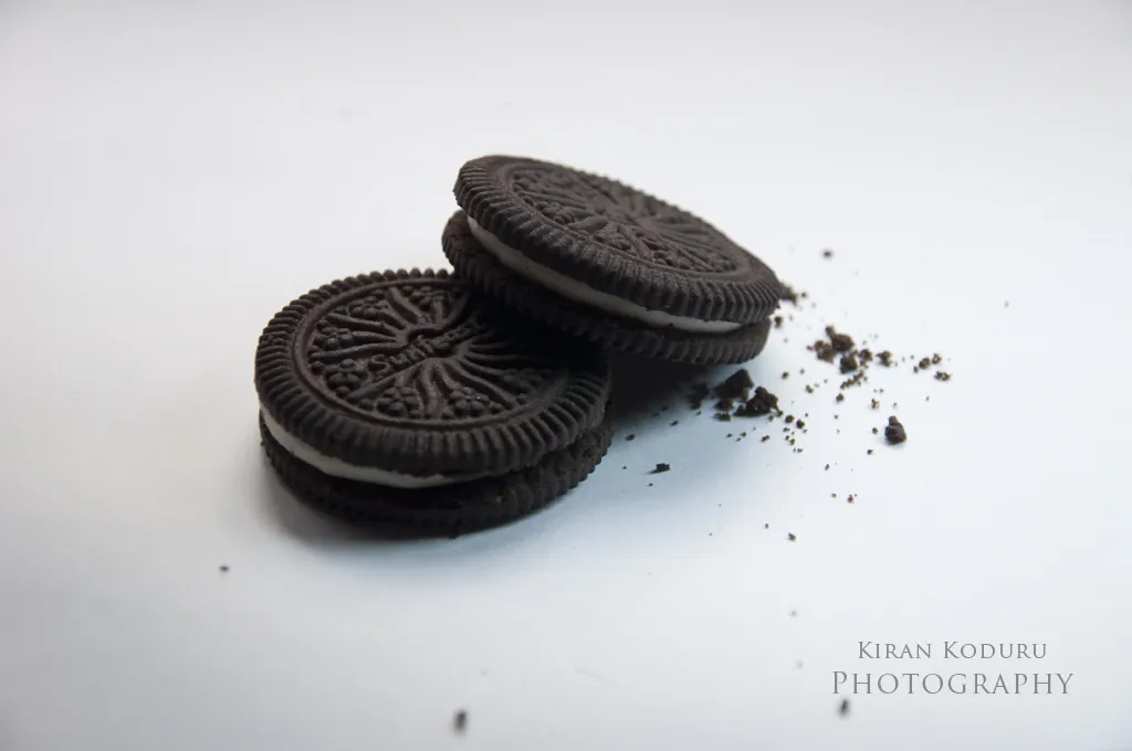 Dos galletas de chocolate con migas sobre fondo blanco